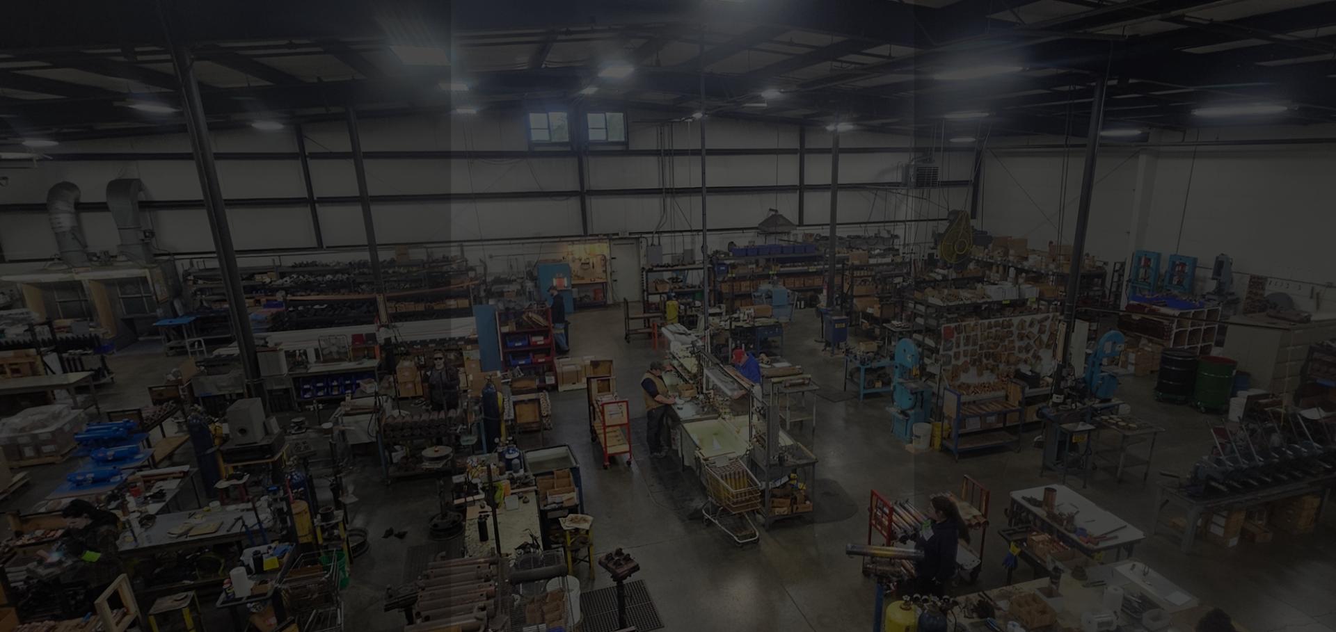 Large industrial warehouse space with workers visible.