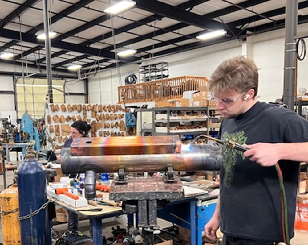 Worker using heat torch in workshop.